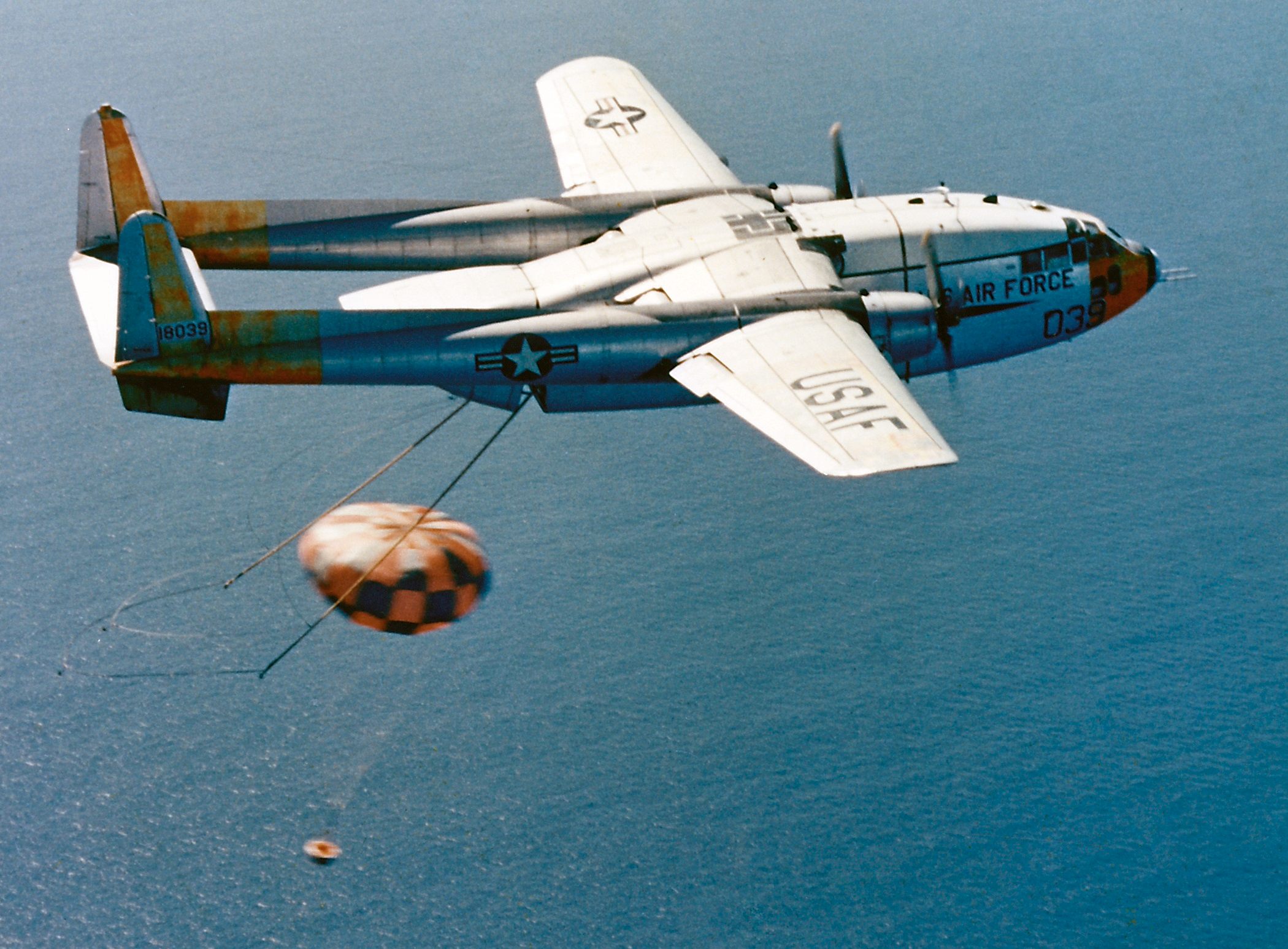 An Air Force plane snags the parachute of a satellite recovery vehicle.